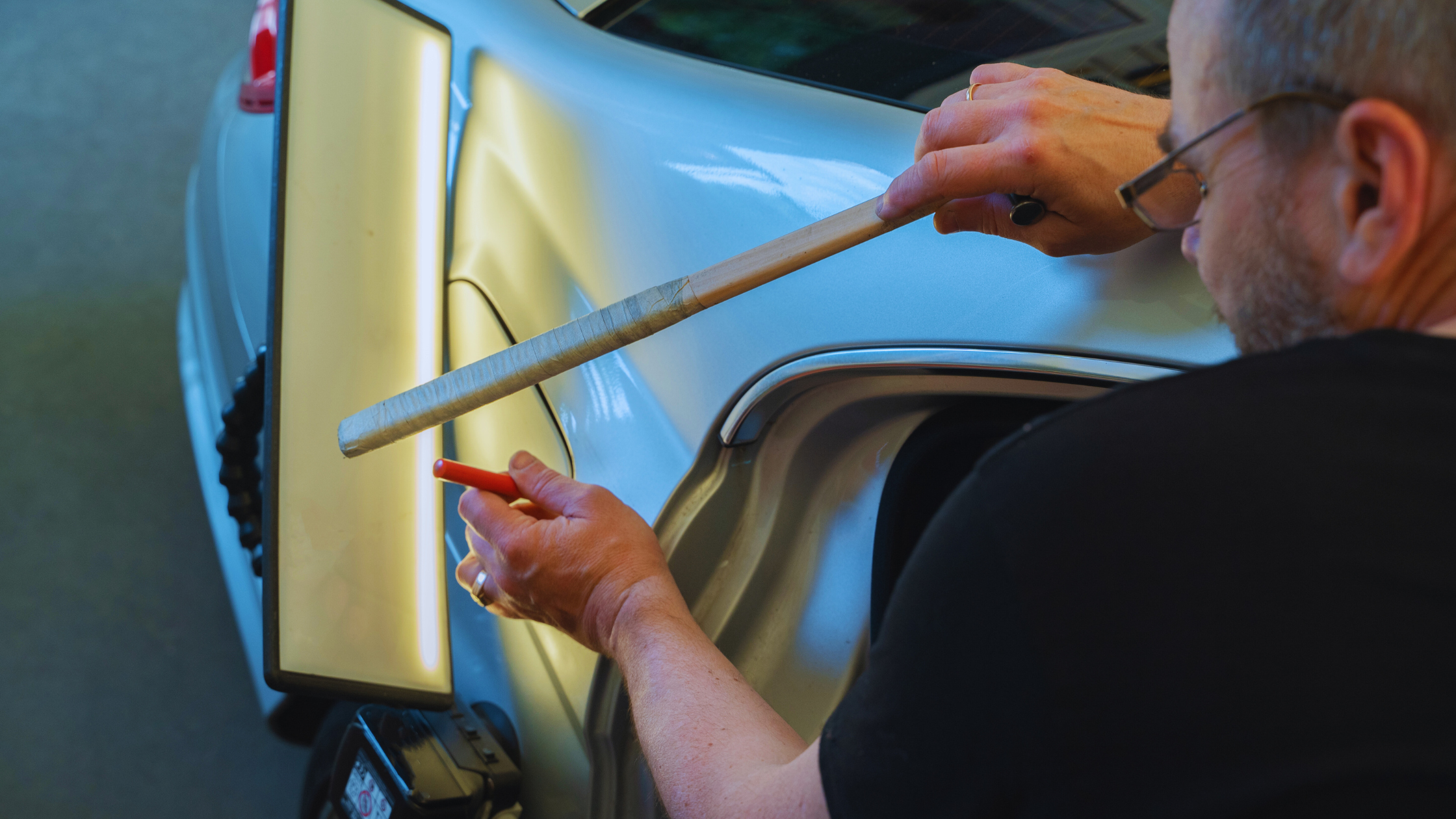 auto body technician performing paintless dent repair