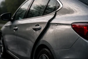Storm-damaged silver sedan close-up